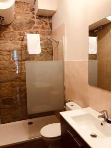 a bathroom with a sink and a toilet and a mirror at Santiaguiño 2 in Padrón