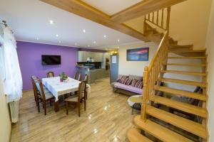 a dining room and living room with a table and stairs at Cichy Zakątek - Sauna Jacuzzi SPA RELAX SOLINA BIESZCZADY in Lesko