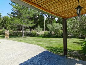 une terrasse couverte avec un toit en bois et une cour herbeuse dans l'établissement Maison San Giovanni, à Corte