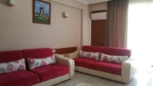 una sala de estar con 2 sofás rojos y una ventana en Haciely Thermal Otel en Denizli