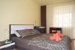 um quarto com uma cama com um bicho de peluche laranja em Spacious 2BDR - FREE Parking - Walk Everywhere - 300 Mbps WiFi em Varna City