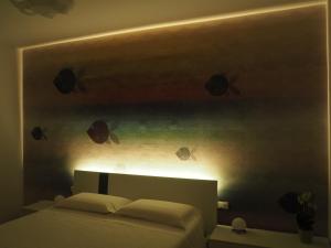 a bedroom with a bed with fish on the wall at Mami al Mare in Duino