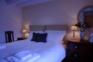 1 dormitorio con 1 cama blanca grande y 2 lámparas en Blairchroisk Cottage en Pitlochry