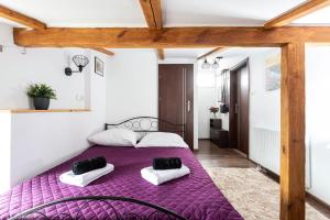 a bedroom with a purple bed with two pillows at Dolce Vita in Gdańsk