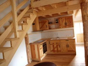 an attic kitchen with wooden cabinets and a staircase at Apartment Schritte in Hinterweiler