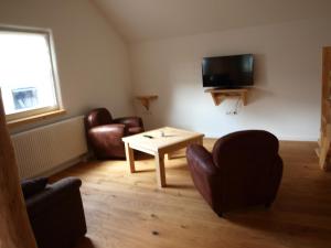 a living room with a couch and a table and a tv at Apartment Schritte in Hinterweiler