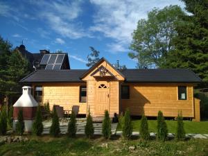 mały drewniany dom z dachem słonecznym w obiekcie Domek na Skarpie w Zakopanem