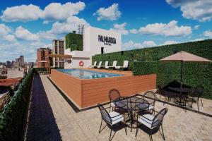 a patio with a table and chairs and a pool at Palmaroga Hotel in Asunción