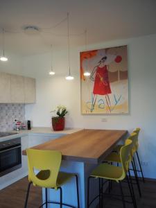 a kitchen with a wooden table and yellow chairs at Mami al Mare in Duino