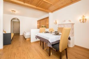 a dining room with a white table and chairs at Pension Margretenhof in Fulpmes