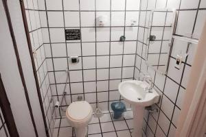 a small bathroom with a toilet and a sink at Novos Baianos Hostel e Pousada in Arraial d'Ajuda