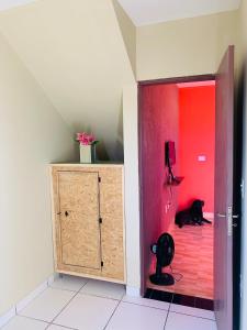 a black cat laying on the floor next to a red door at Casa em Gravata mobiliada in Gravatá