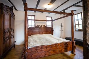 a bedroom with a wooden canopy bed in a room at Rißbacher Hof anno 1737 in Traben-Trarbach
