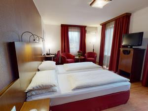 a hotel room with two beds and a television at Hotel Via Roma in Salzburg