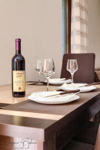 een fles wijn op een houten tafel met glazen bij Apartments Donkovic in Kotor
