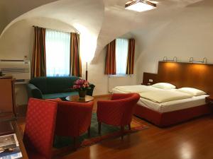 ein Schlafzimmer mit einem Bett und einem Tisch und Stühlen in der Unterkunft Hotel Via Roma in Salzburg