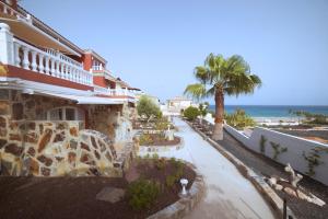 a building with a walkway next to the ocean at Casa Roja in Costa Calma