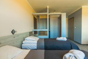 two beds in a room with a cross on the wall at Resident Rene in Ustka