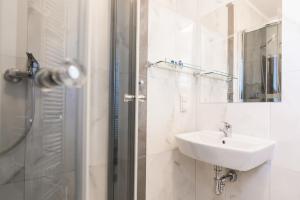 W łazience znajduje się umywalka oraz prysznic z lustrem. w obiekcie Resident Rene w Ustce