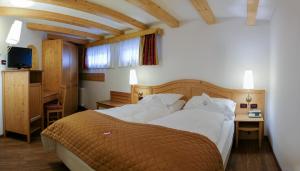 Een bed of bedden in een kamer bij Hotel Alpino Al Cavalletto
