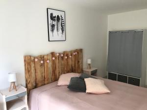 um quarto com uma cama e uma cabeceira em madeira em Gîte chez Julie et Jp em Neufchâteau