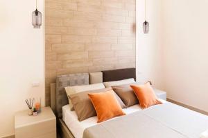 - une chambre avec un lit blanc et des oreillers orange dans l'établissement Casa Neva, à Trani