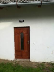 a brown door on the side of a white building at Ubytování na farmě v Novohradských horách in Horní Stropnice