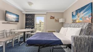 a hotel room with a bed and a table and chairs at Adventurer Oceanfront Inn in Wildwood Crest