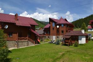 a large wooden house with a yard in front of it at Aura Karpat in Bukovel