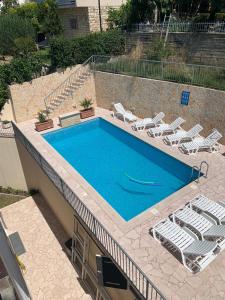 a swimming pool with lounge chairs and a swimming pool at Apartments Toni 2000 in Podstrana