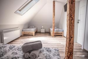 a attic room with two beds and a skylight at Domek u Mai in Zator