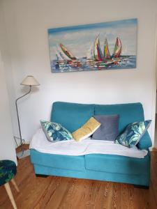 a blue couch in a living room with a painting at le castor in Deauville