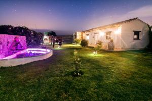 a backyard with a hot tub in the grass at night at La Vega del Prado in Tarifa