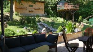 a patio with a couch and a table and chairs at Planinska kuća "Zvuk Tišine" - Fruška gora in Beočin