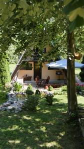 une cour avec une maison avec une tente et un arbre dans l'établissement Planinska kuća "Zvuk Tišine" - Fruška gora, à Beočin