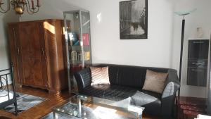 a living room with a black couch and a glass table at Appartement zum Entspannen in Wartenberg