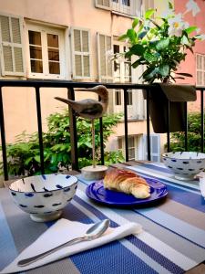 une table avec un plateau avec un croissant et des bols. dans l'établissement Studio Chateau - Vieux Nice, à Nice