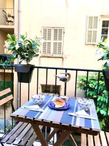 a blue table with a plate of food on a balcony at Studio Chateau - Vieux Nice in Nice