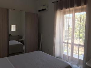 1 dormitorio con cama y ventana grande en Domus 127 Apartment Pompei, en Pompeya