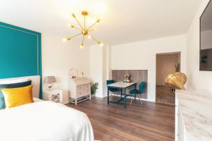 a bedroom with a bed and a table with a chair at GATSBY Apartment in Gelsenkirchen