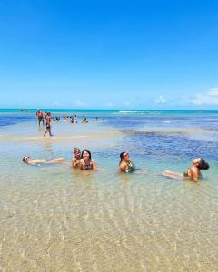 a group of people in the water at the beach at Sua Casa em Flecheiras in Flecheiras
