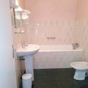 a bathroom with a sink and a toilet and a tub at Hôtel Sampiero Corso in Corte