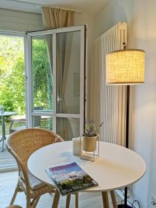 a white dining room table with a lamp and chairs at Lillys Apartment Kempten in Kempten