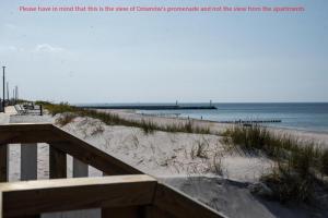 a view of a beach with a wooden boardwalk and the ocean at Apartamenty Marynarki Wojennej, Dziwnów in Dziwnów