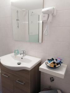 een badkamer met een wastafel en een spiegel bij Nini's House 1 in Nydri
