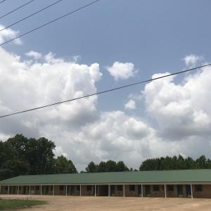 ein langes Gebäude mit grünem Dach und Wolken am Himmel in der Unterkunft Linder Motor Lodge in Homer