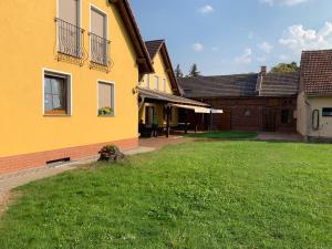 a yellow house with a lawn in front of it at Ferienwohnung Hofapartment in Milkersdorf