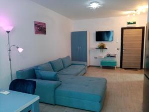 a living room with a blue couch and a table at Sunrise in Mamaia Nord