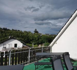 eine Terrasse mit einem Tisch und Stühlen auf dem Balkon in der Unterkunft Gruppenferienhaus Zum Rabenhorst für bis zu 16 Personen am Waldrand gelegen in Hallenberg