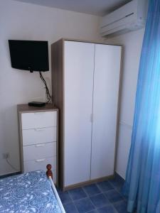 een slaapkamer met een bed en een kast met een televisie bij Ferienhaus Bozena Appartment 1 in Vrsar